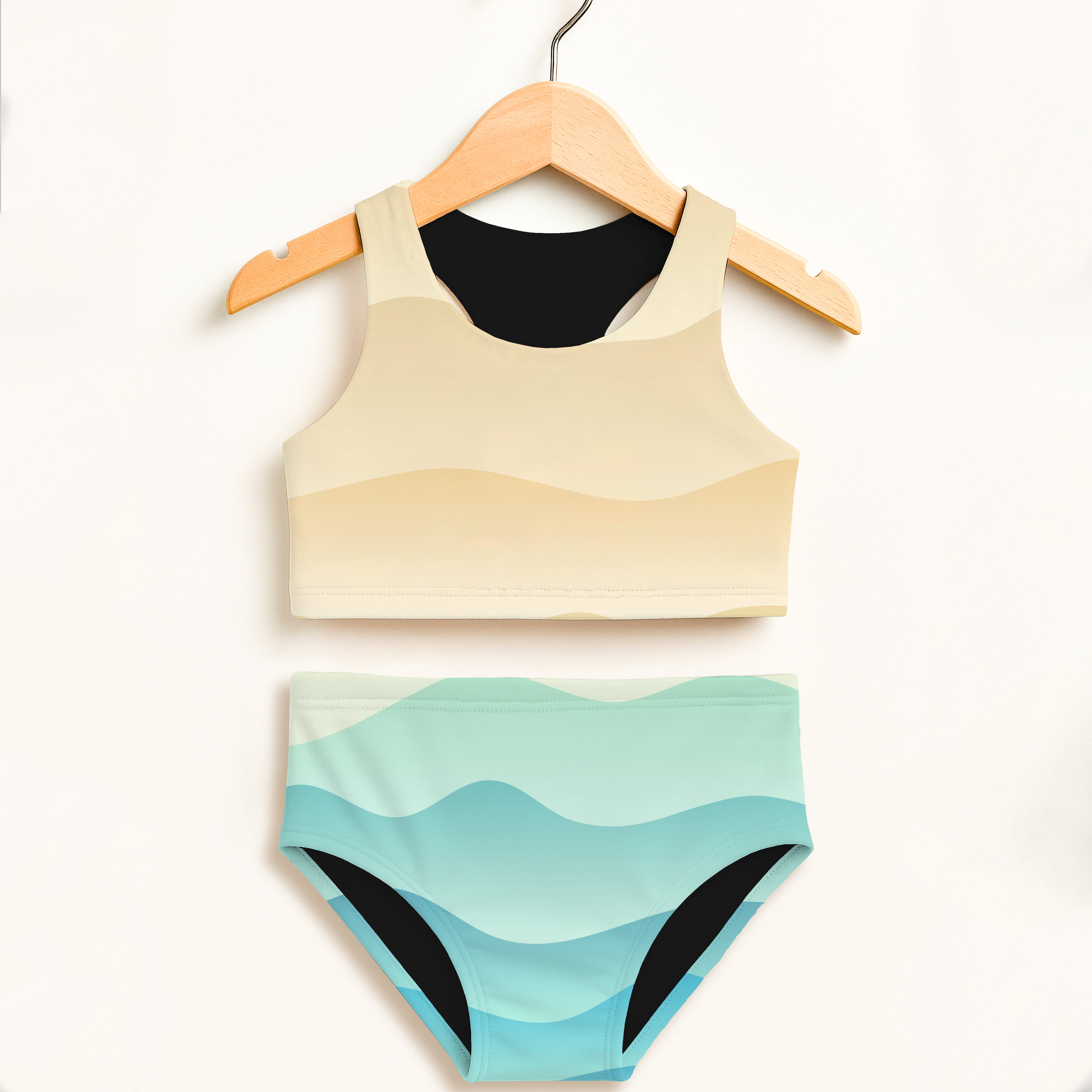 Girls wavy sand two piece swimsuit in beige and teal wave pattern with black trim and double layered upf 50 plus fabric
