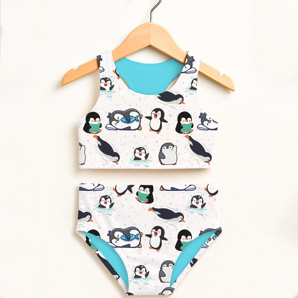 Girls penguin two piece swimsuit in white and teal with playful cartoon design double layered UPF 50 plus high waisted comfort