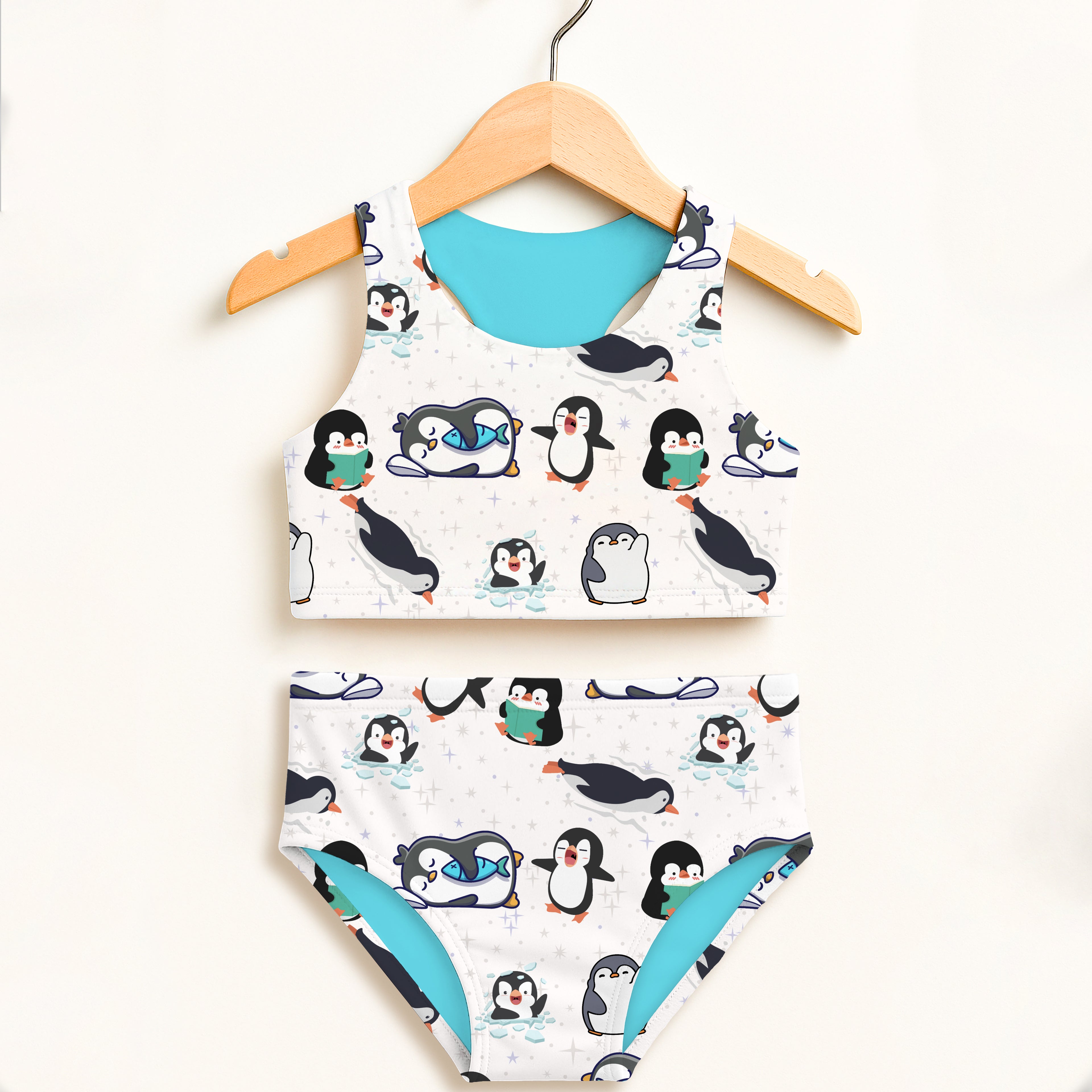 Girls penguin two piece swimsuit in white and teal with playful cartoon design double layered UPF 50 plus high waisted comfort