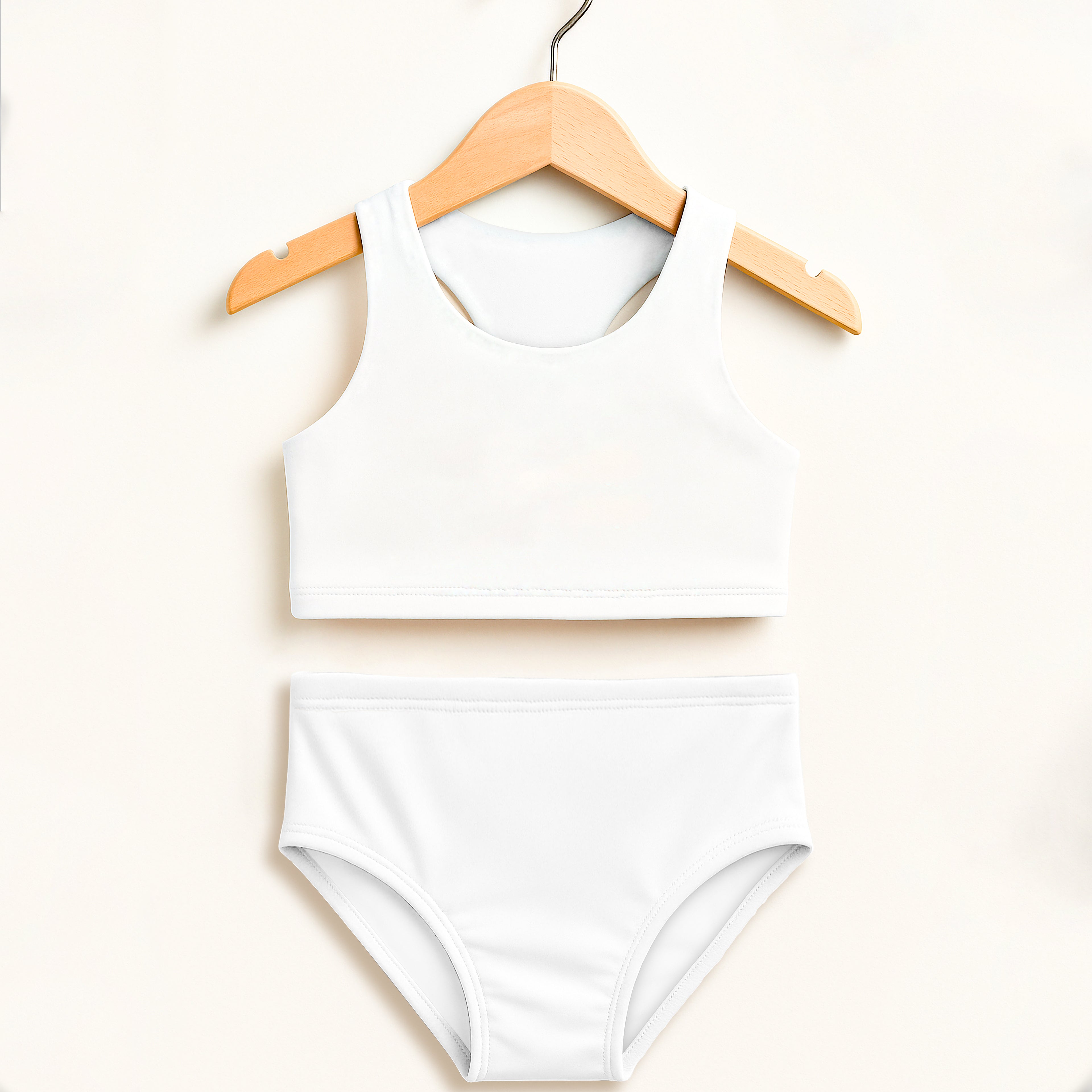 Girls white two piece swimsuit with racerback top and high waisted bottoms on wooden hanger