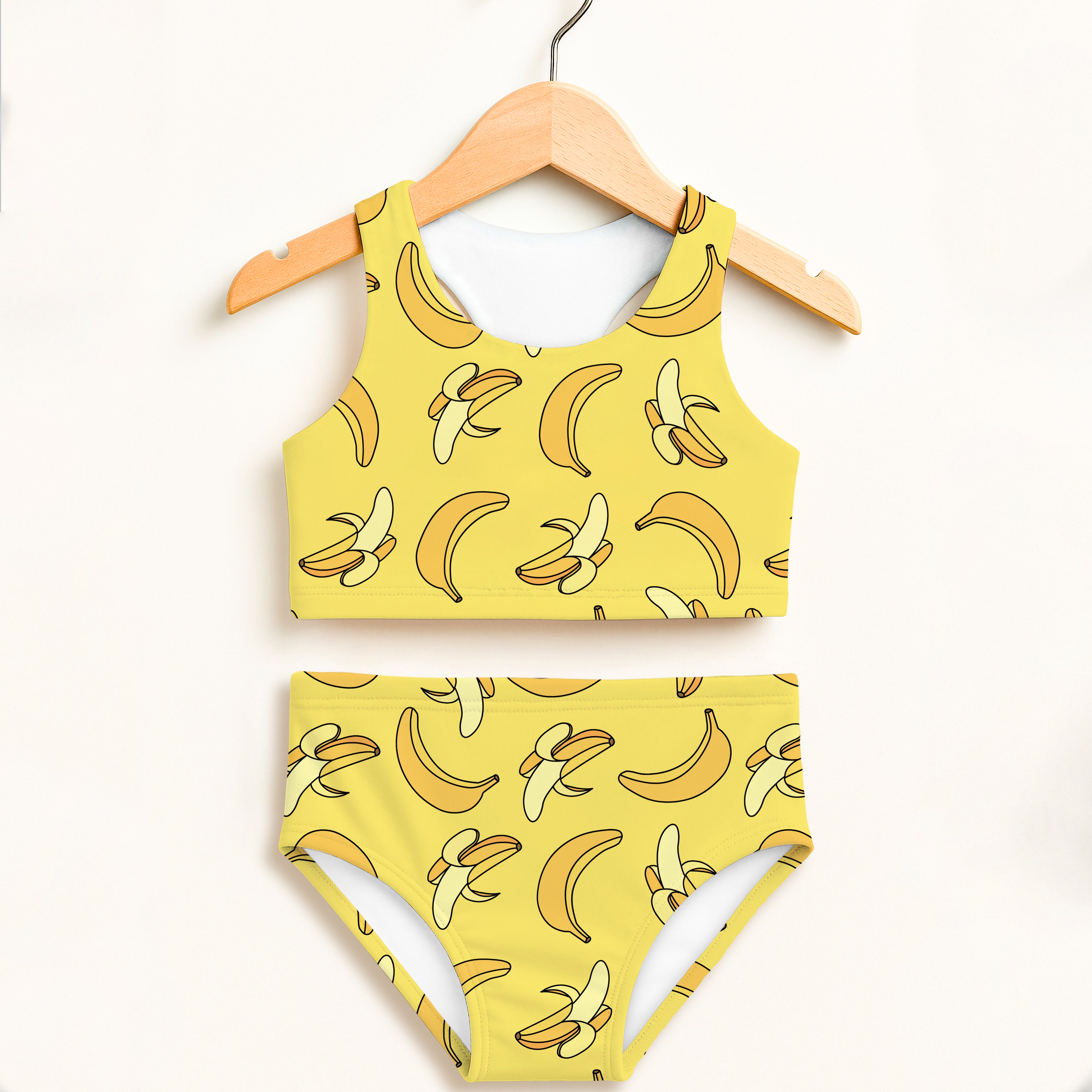 Girls yellow banana print two-piece swimsuit hanging on wooden hanger double layered upf 50 plus high waisted comfort