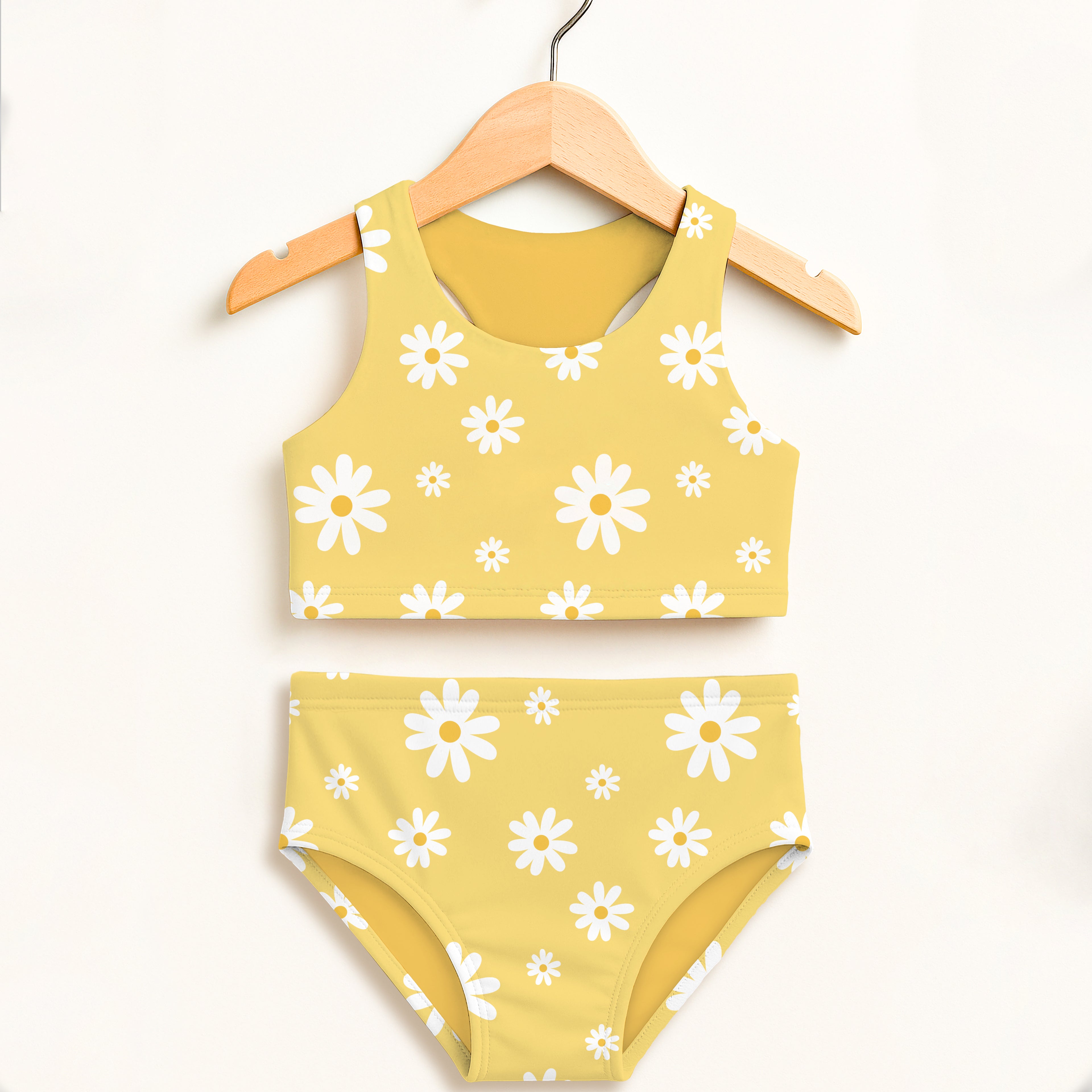 Girls yellow daisy two piece swimsuit with double layered upf 50 plus fabric hanging on a wooden hanger